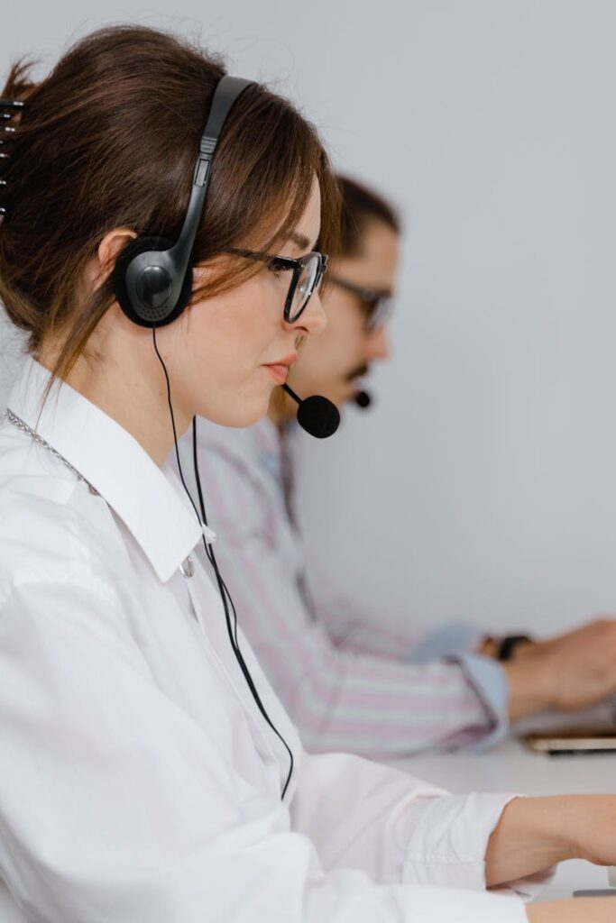 Customer service agents working at call center with headsets, focused on providing support.